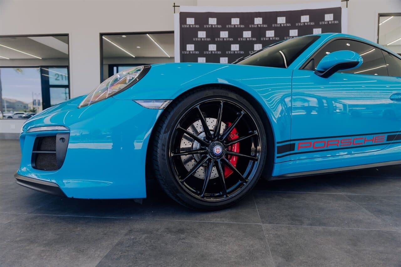 Blue Porsche 911 in a dealership showroom